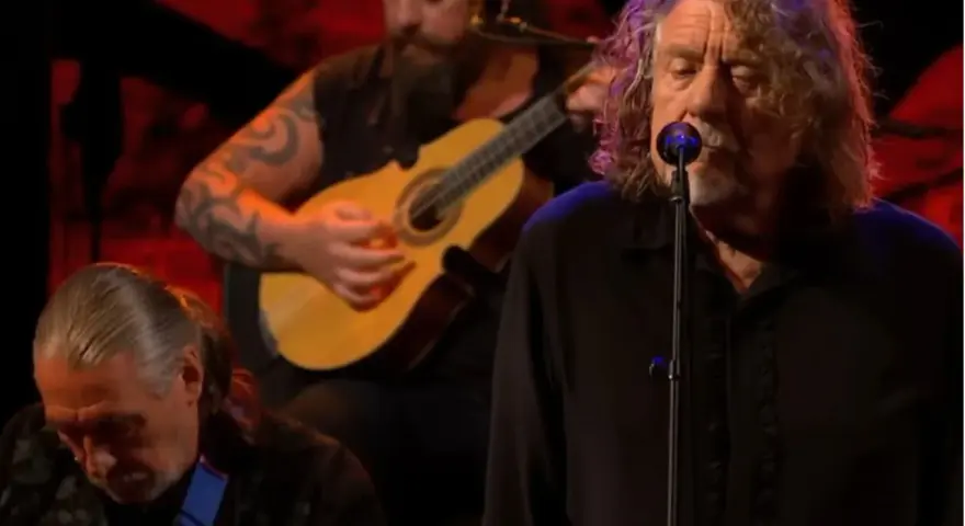 Robert Plant, le légendaire chanteur de Led Zeppelin, en pleine performance, accompagné de musiciens jouant de la guitare.