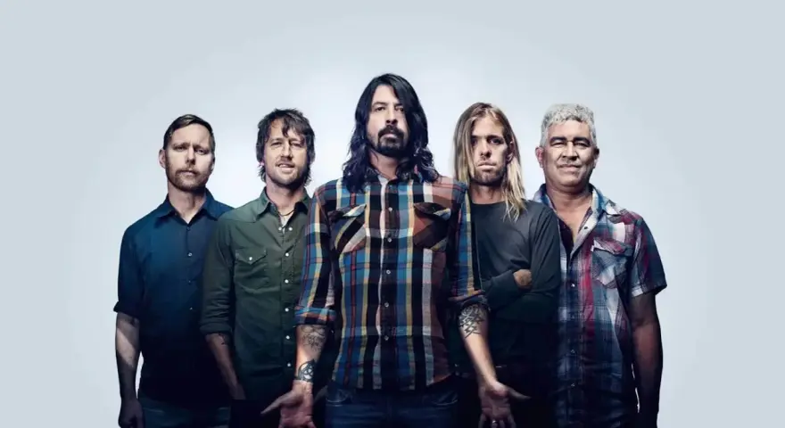 Les cinq membres du groupe Foo Fighters posent ensemble, prêts à faire vibrer le public avec leur musique.