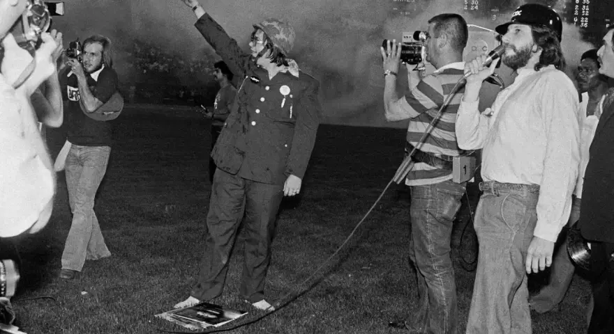 Un homme en uniforme militaire, bras levé, au milieu d'une foule et de caméras. Une scène qui pourrait faire partie de l'histoire du disco.