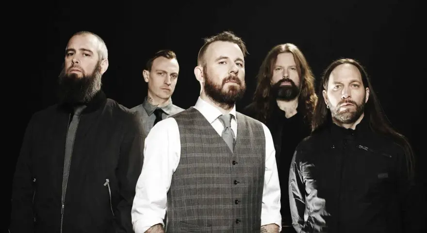 Cinq hommes barbus, membres du groupe In Flames, posent devant un fond noir.