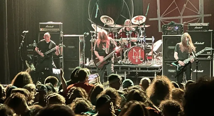 Concert de metal, musiciens sur scène, foule en délire. Le groupe semble prêt à envoyer du lourd, un vrai voyage ad patres pour les fans.