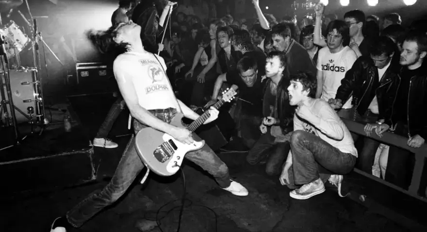 Un groupe rock irlandais des années 90 en pleine action. Le guitariste, cheveux au vent, électrise la foule en délire.