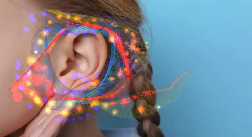 Une oreille capte des ondes sonores colorées, suggérant un seuil de douleur db.
