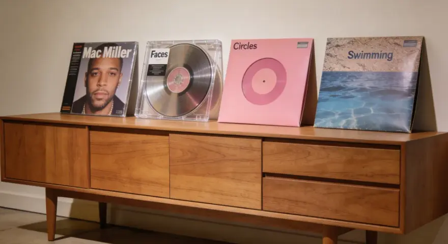 Collection de vinyles de Mac Miller : "Mac Miller", "Faces", "Circles" et "Swimming" sur un meuble en bois.