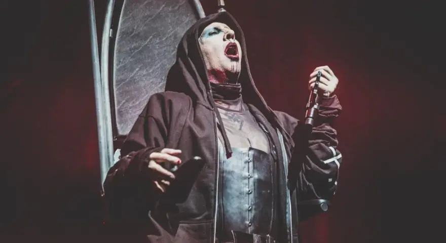Marilyn Manson, le visage maquillé, chante sur scène, micro en main. Les dernières marilyn manson news le montrent toujours aussi provocateur.