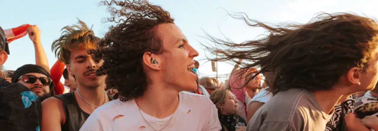 Foule en délire, cheveux au vent. Le jeune homme porte des bouchons d'oreilles, peut on laver des boules quies en mousse pour les réutiliser ?