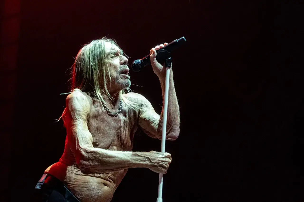 Iggy Pop, le parrain du punk, chante sur scène, micro à la main. Son groupe, toujours aussi électrique, l'accompagne.