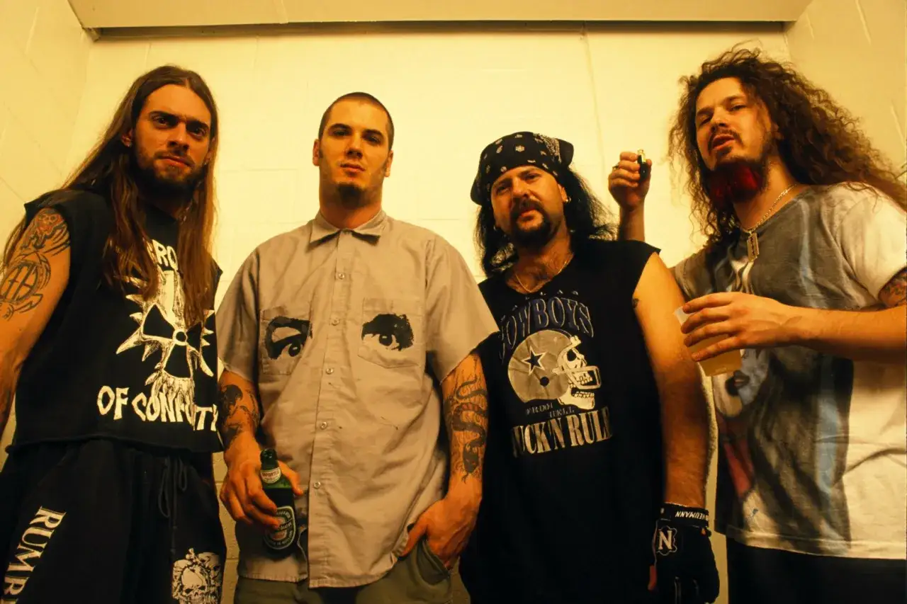 Les membres de Pantera posent ensemble, certains tenant des bières et des shots.