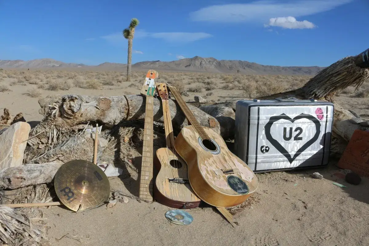 Guitare et valise U2 dans le désert, près d'un Joshua Tree.