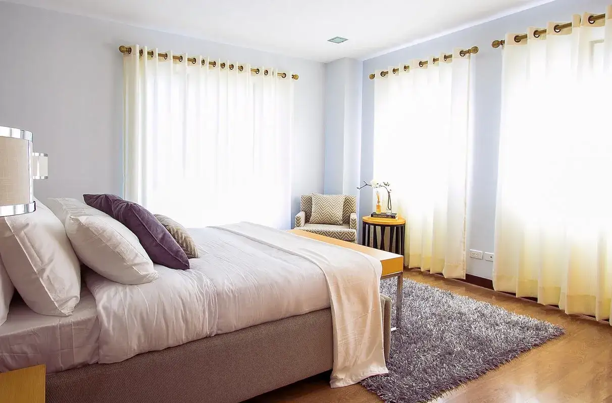 Chambre paisible avec lit douillet et rideaux clairs. Idéal pour savoir combien de décibels pour dormir sans être dérangé.