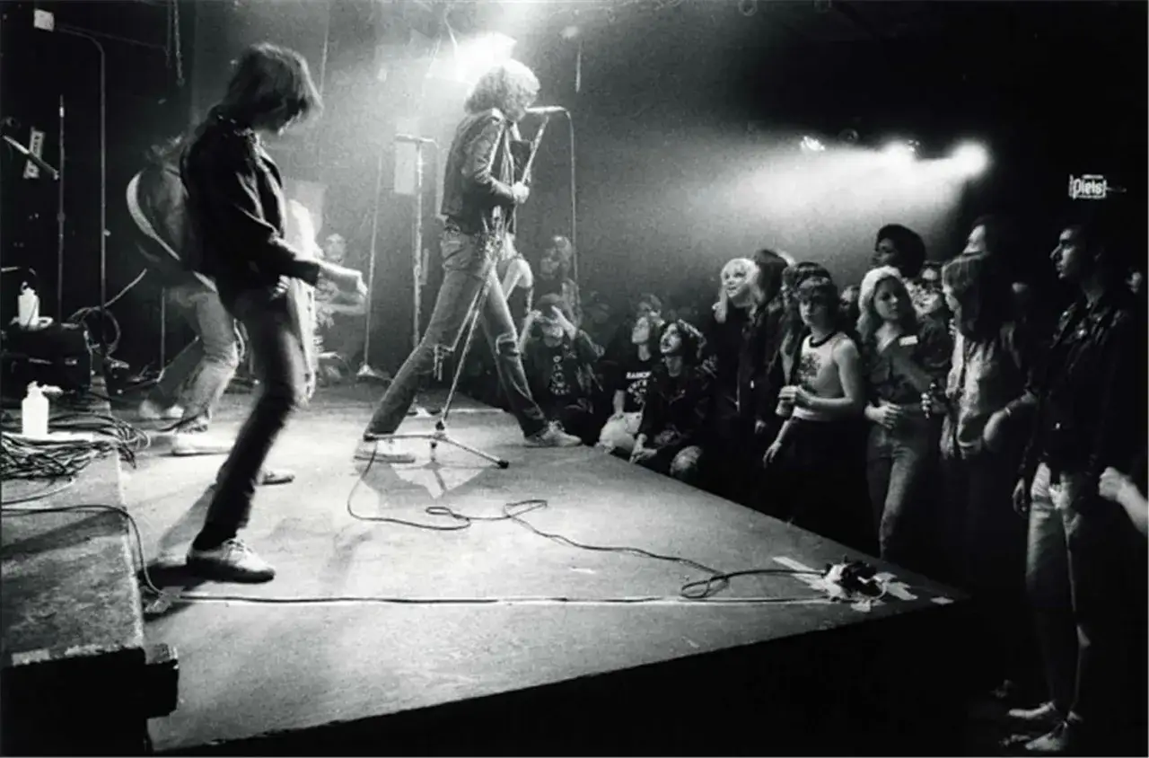 Concert des Ramones, groupe de punk rock, sur scène devant une foule en délire.