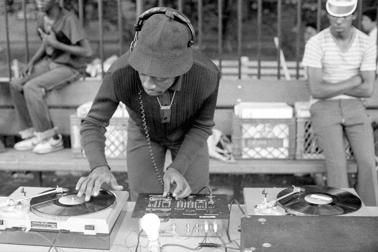 Un DJ aux platines, peut-&ecirc;tre un pionnier de qui a invent&eacute; le rap, cr&eacute;e l'ambiance pour la foule.