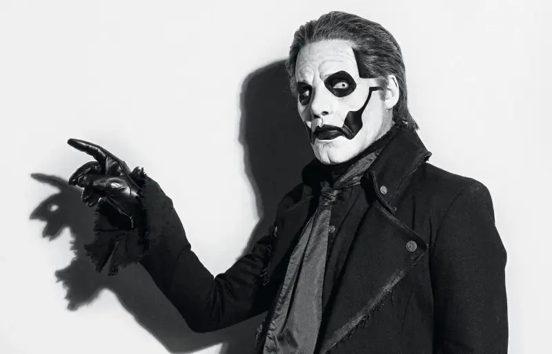 Le chanteur de Ghost, Papa Emeritus IV, pointe du doigt avec un gant noir, son visage maquillé en squelette.